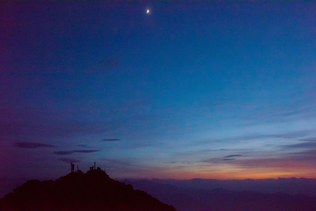 夕焼けと月と登山者と