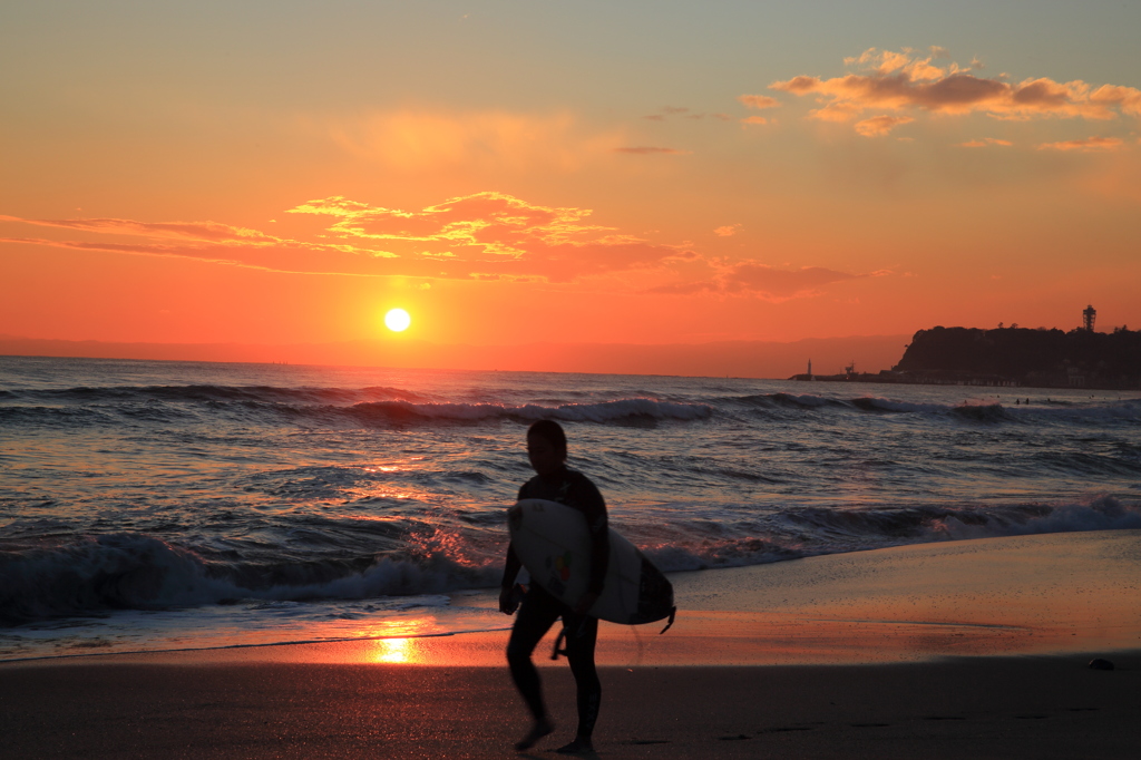 沈む夕日去りゆくサーファー
