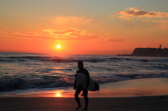 沈む夕日去りゆくサーファー