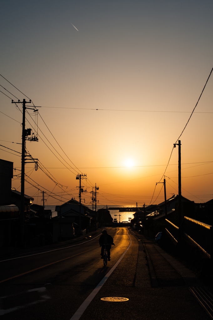 夕暮れの坂道、登板の自転車。
