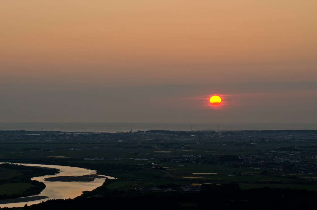 最上川と日本海に落ちる夕日