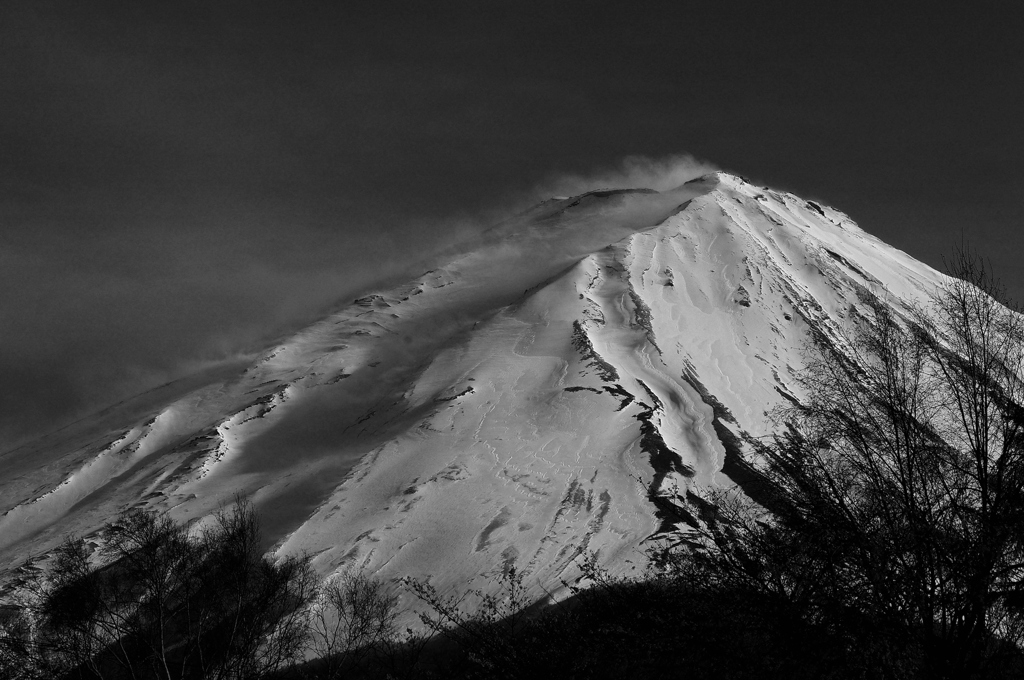 山頂雪煙の上がる富士山