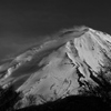 山頂雪煙の上がる富士山
