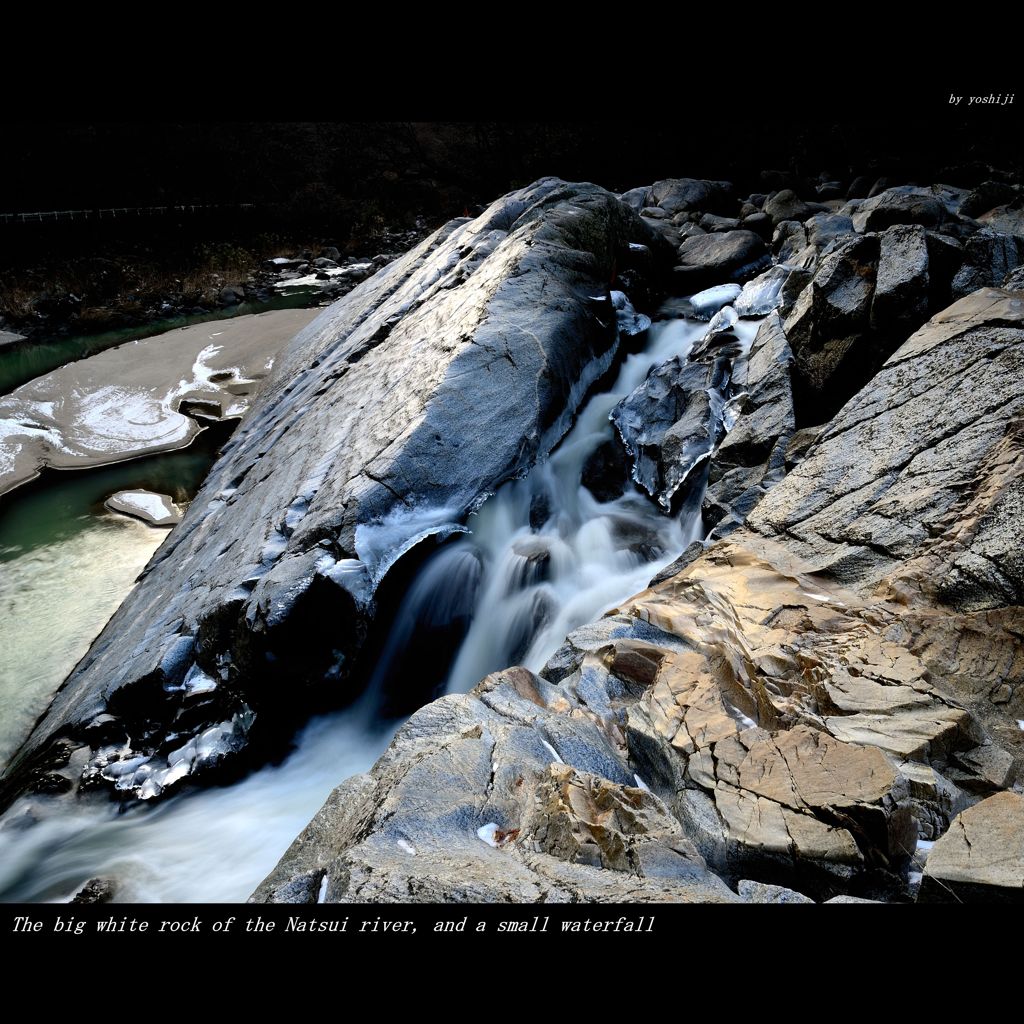 A big white rock and a small waterfall