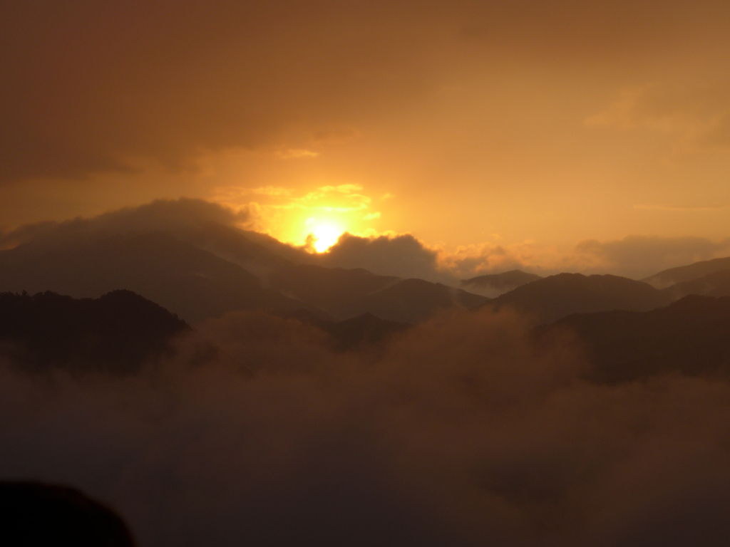 霧の山から太陽が