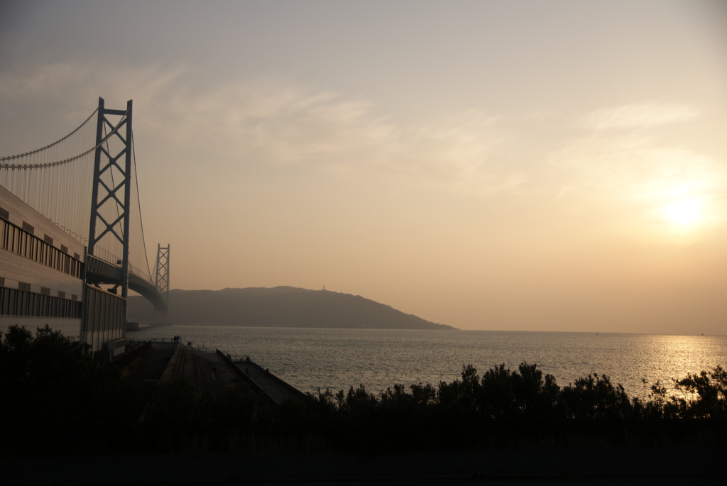 夕暮れ時の太陽と橋と海
