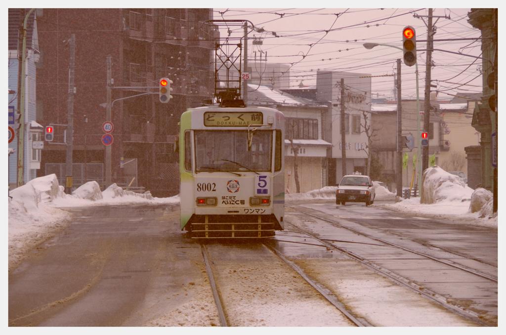 雪降る函館の町を走る路面電車・・