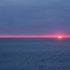 水平線と雲の間に沈む夕日