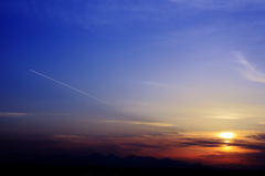 飛行機雲と夕日