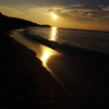 沈む夕日に波音が響く