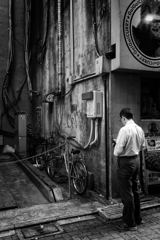 壁、自転車と男