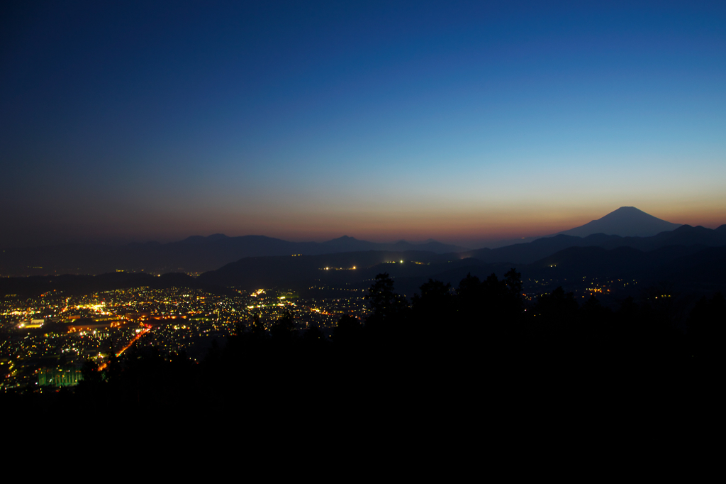 黄砂に浮かぶ富士山と夜景。