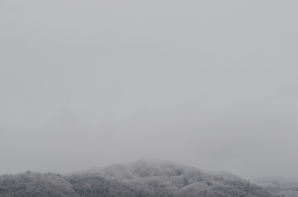 遠くの山に雪が降っている