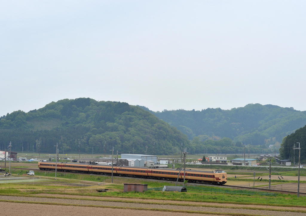 曇り空の田園風景を行く