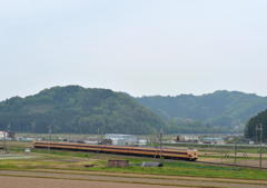 曇り空の田園風景を行く