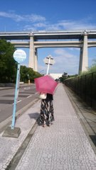 バス停の赤い傘の女