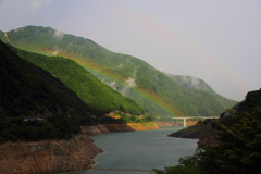 ダム湖上にかかる虹