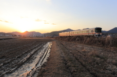春待ちの夕陽を背に