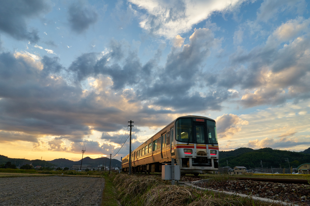 夕陽と雲がせめぎあう空を走る