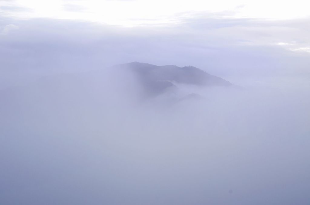 煙る山