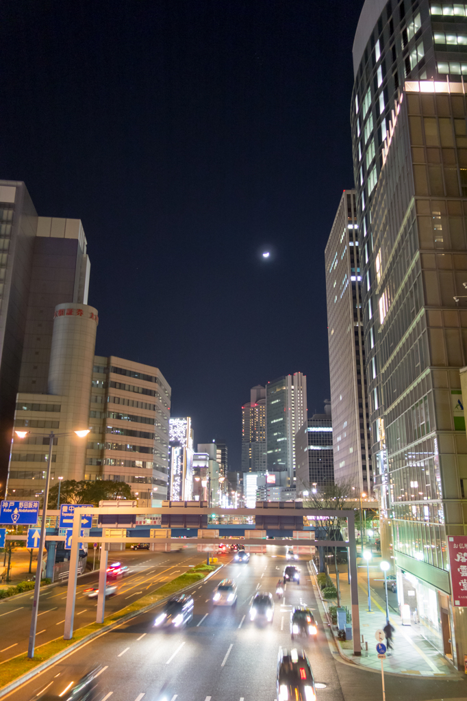 月とビルと走る車