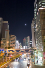 月とビルと走る車