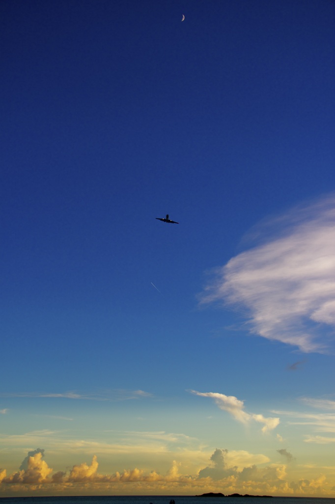 月と飛行機と海と飛行機雲
