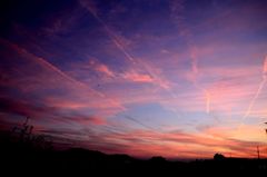 夕日に向かう飛行機雲