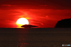 島を侵食するダルマ夕日