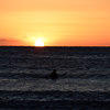 日の出とサーファー