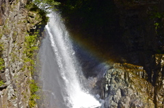 A water fall with a small rainbow 