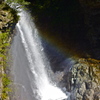 A water fall with a small rainbow 
