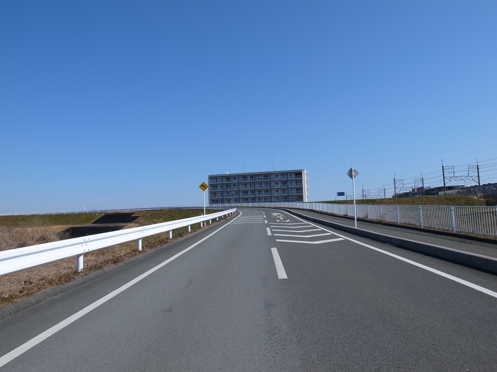 道路とマンションと青空