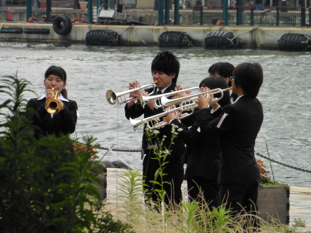 港でコーラスの練習をする若者