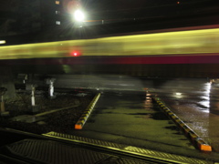 夜の踏切の通過列車