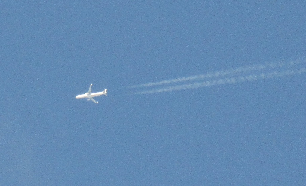 はるか上空を飛行する機体　飛行機雲