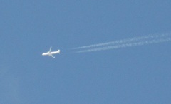 はるか上空を飛行する機体　飛行機雲