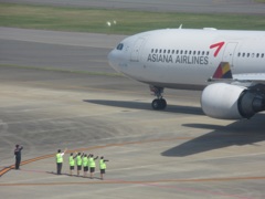 出発するアシアナと手を振って見送る社員