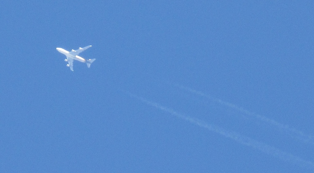 上空を通過する４発機と飛行機雲