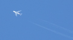 上空を通過する４発機と飛行機雲