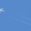 上空を通過する４発機と飛行機雲