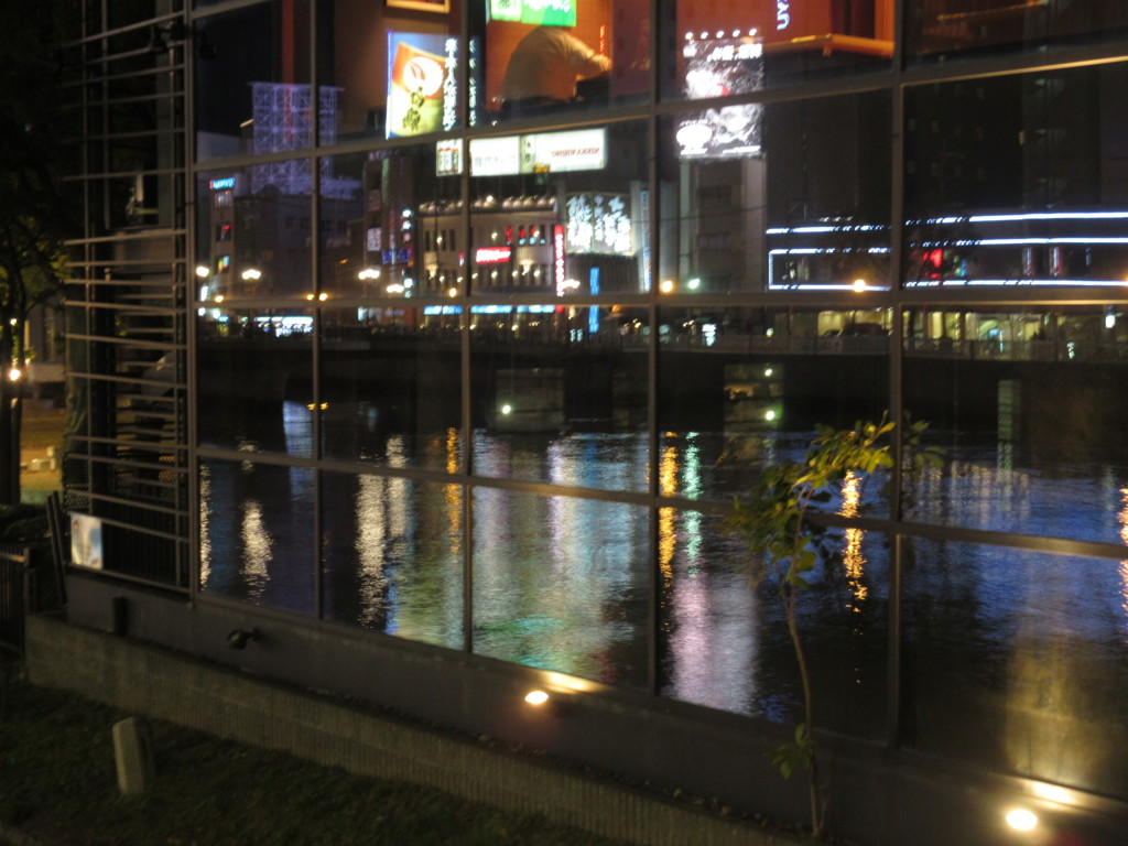 ガラスに写りこむ夜の中州と川