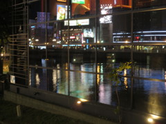 ガラスに写りこむ夜の中州と川