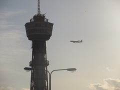 博多ポートタワーと上空を通過する飛行機