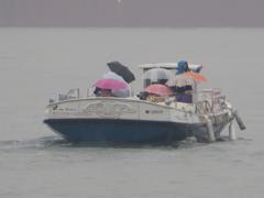 雨の中船旅をする人たち