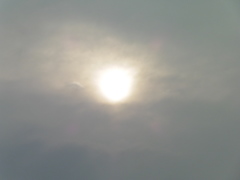 雲に隠れうっすらと見える夕日