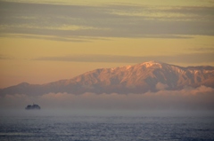 朝日に染まる雪山と多景島