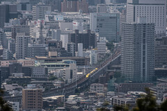 岡山駅を出た黄色い新幹線　遠景