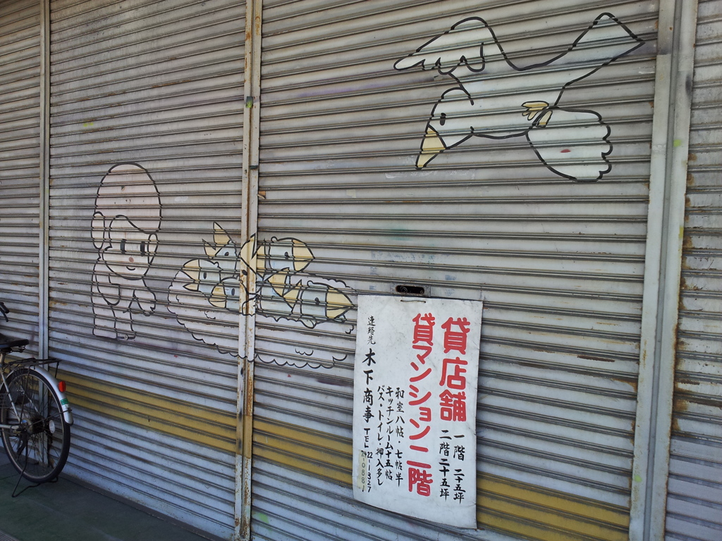2017/05/18_古そうな商店街のシャッターにほのぼのイラスト