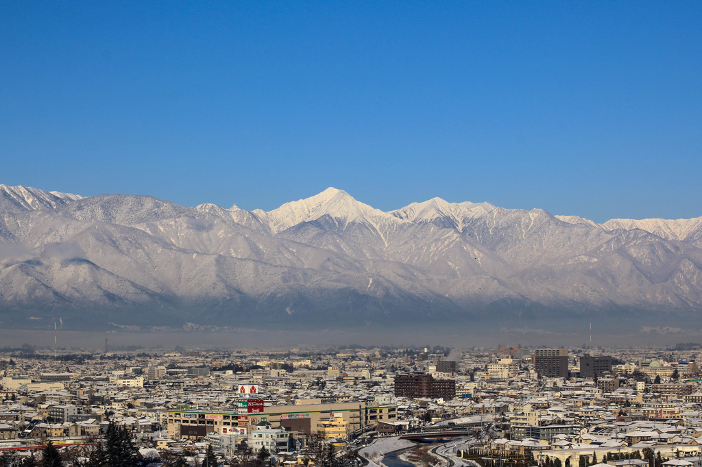 雪の常念岳と松本市内